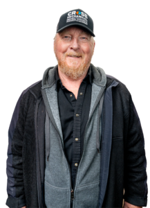 Eric Crose of Crose Mechanical, smiling, wearing a Crose Mechanical cap and work jacket