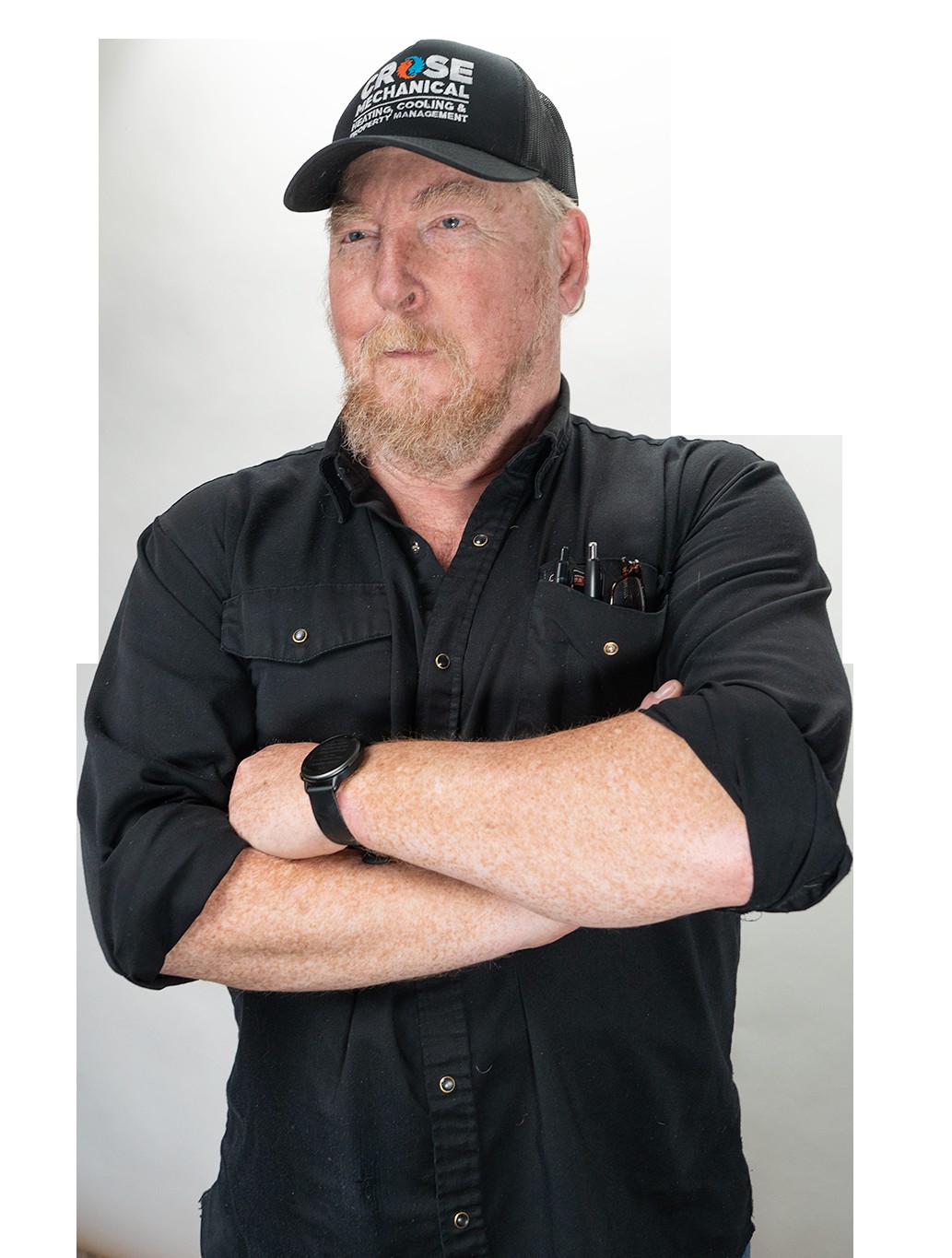 Eric Crose standing with arms crossed, confident portrait in black shirt and cap